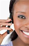 Close up of smiling woman using her phone on white background