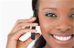 Close up of smiling woman using her mobile phone on white background