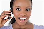 Close up of surprised looking young woman on the phone on white background