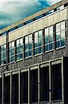 Close-up on industrial, modern building. Glass, concrete and sky.