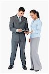 Business partner looking at clipboard together against a white background