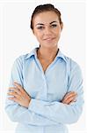 Smiling businesswoman with arms folded against a white background