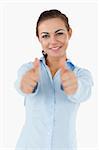 Smiling businesswoman giving both thumbs up against a white background