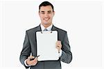 Businessman pointing with pen on clipboard against a white background