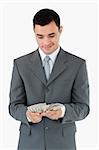 Businessman counting bank notes against a white background