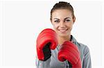 Smiling businesswoman with boxing gloves against a white background