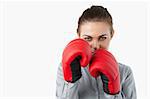 Young businesswoman with boxing gloves against a white background