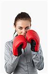 Businesswoman with boxing gloves on against a white background
