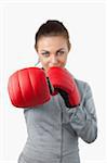 Boxing gloves used to slam by businesswoman against a white background