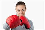 Boxing gloves used to slam by young businesswoman against a white background
