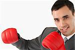 Side view of businessman with boxing gloves against a white background