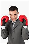 Close up of smiling businessman with boxing gloves on against a white background