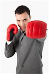 Close up of businessman's fist in a boxing glove against a white background