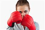 Close up of serious businesswoman with boxing gloves against a white background