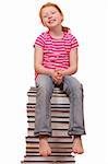 Portrait of a red haired girl sitting on a pile of books