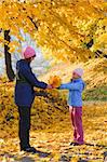 Happy family (mother with daughter) walking in golden maple autumn park
