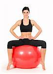Brunette woman excercising with a pilates ball - studio shot