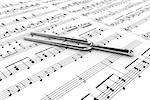 Silver tuning fork on a  background written notes