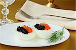 Boiled eggs with red and black caviar