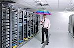 young handsome business man  engineer in   businessman hold  rainbow colored umbrella in server datacenter room  and representing security and antivirus sofware protection concept