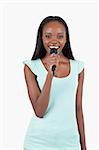 Brightly smiling young female singer against a white background