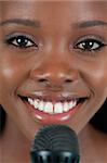 Close up of cheerful smiling female singer with microphone