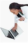 Smiling woman typing in her credit card information against a white background