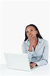 Portrait of a thoughtful businesswoman using a laptop against a white background