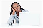 Bored businesswoman using a laptop against a white background