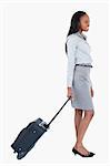 Portrait of a businesswoman walking with a suitcase against a white background