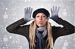 pretty long haired blonde making a funny face wearing a woolen sweater, gloves, a scarf and a woolen cap