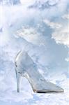 a glass slipper in a cloudy blue sky background with clipping path