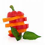 Red and orange pepper vegetables sliced in a stack with leaf spring isolated over white background.