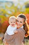 Portrait of happy mother with smiling baby on street