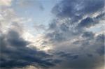 Stormy weather sky with sun shining through clouds