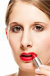 closeup of a beautiful woman applying lipstick on white background