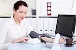 Beautiful caucasian businesswoman measuring her blood pressure in the office.