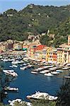 Vertical oriented image of famous town of Portofino with small bay full of yachts and boats on Ligurian sea, northern Italy.