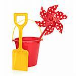 Toy windmill with beach bucket and spade in red and yellow colours isolated over white background.