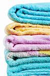 Stack of bright colorful towels over white background