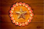 christmas candles circle over wood and golden star symbol