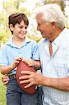 Grandfather And Grandson Playing American Football Together