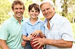 Grandfather With Father And Son Playing American Football Together