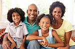 Young Family Relaxing On Sofa At Home