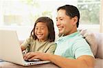 Father And Daughter Using Laptop At Home