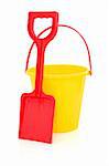 Beach bucket and spade toys in red and yellow isolated over white background.