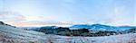 First autumn frost on pasture with haystacks and sunrise in the mountains village.  Three shots stitch image.