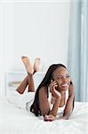 Portrait of a woman making a phone call in her bedroom