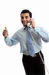 A successful businessman on the telephone.  He is showing thumbs up approval, great, success, hand sign.  White background.