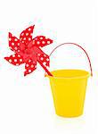 Toy windmill in red with polka dots and yellow plastic bucket isolated over white background.